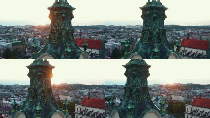 无人机飞到乌克兰利沃夫的拉丁大教堂尖顶附近，在真实的老城区城市景观天际线上露出日落。