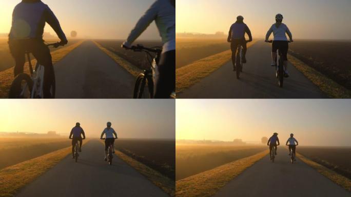 日落时分，一对夫妇骑着山地车在乡间小路上骑行