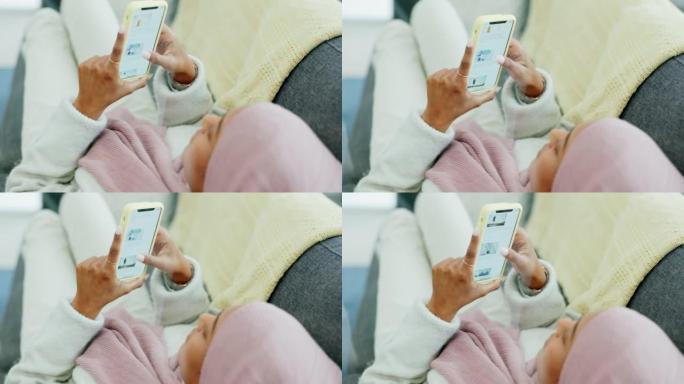 社交媒体，电话和双手，一名穆斯林妇女躺在她家客厅的沙发上，阅读头条新闻。女性通过移动技术放松，浏览和