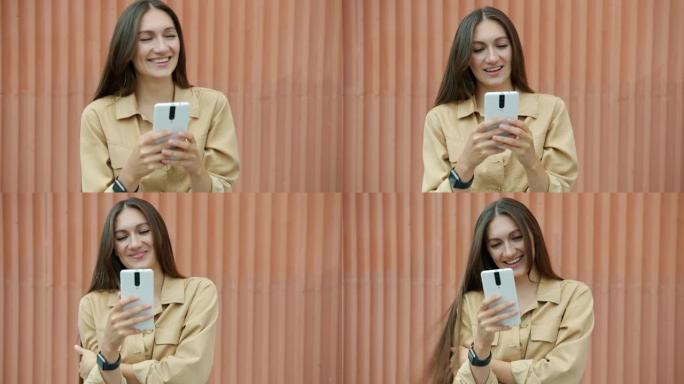 快乐女人的肖像使用智能手机笑着享受户外社交媒体交流