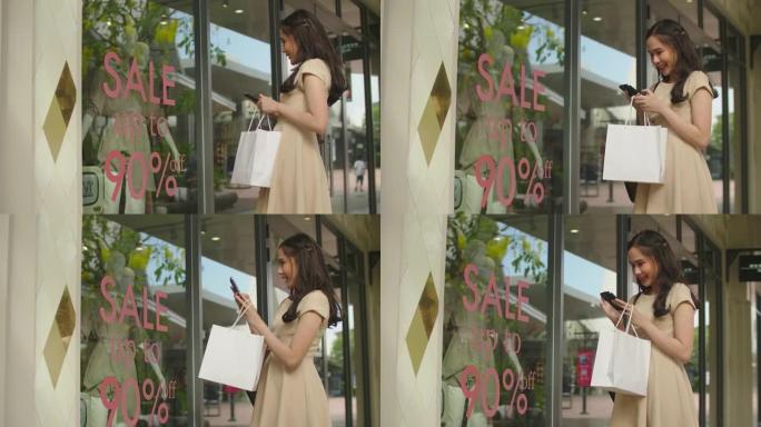 年轻的亚洲妇女看着商店的橱窗