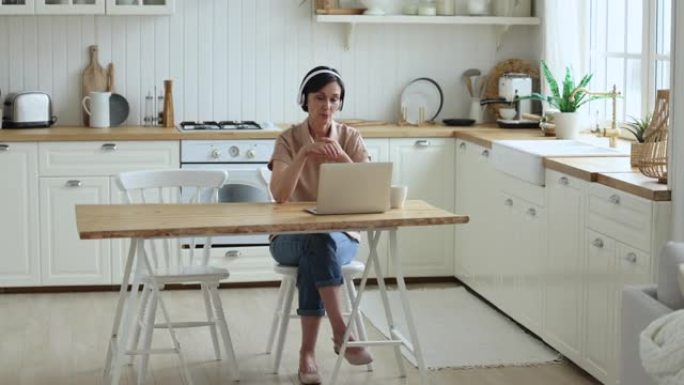 使用笔记本电脑和可视电话应用程序在家工作的成熟女性