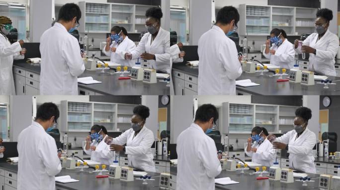 在实验室工作的多种族学生戴着口罩