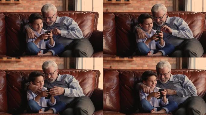 爷爷看他的小孙子如何在手机上玩电子游戏