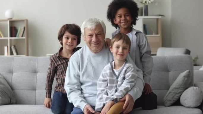 三个多种族的小孙子拥抱他们的老曾祖父