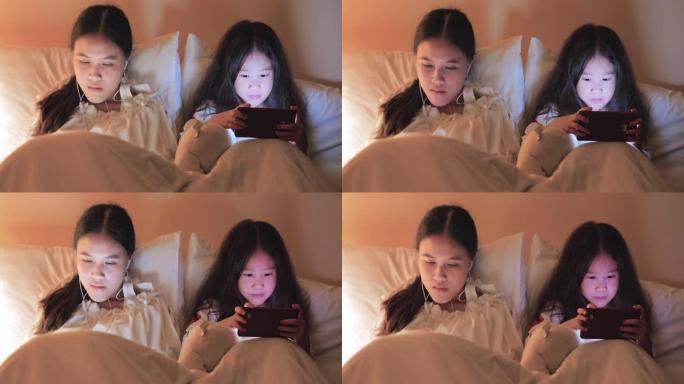 睡前在床上使用智能手机的儿童女孩