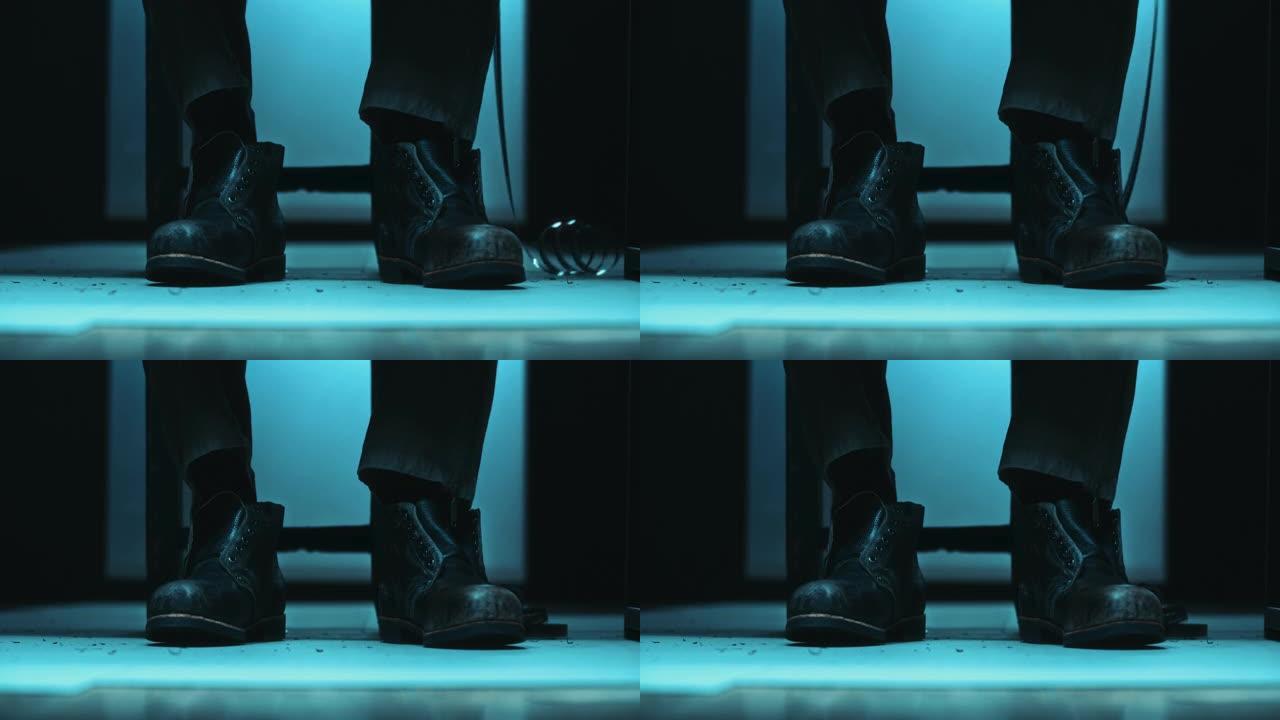 60年代80年代的皮革男鞋在冷光照亮的桌子下。8毫米电影落在脚旁边。