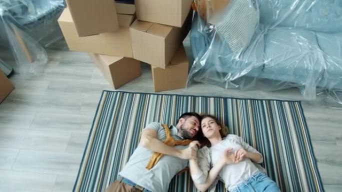 女友和男朋友在谈论制定计划躺在新房子的地板上
