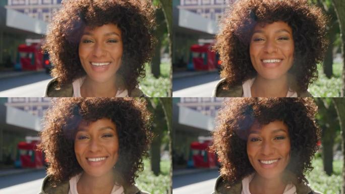 一个美丽而自信的黑人女性的脸，一个卷曲的非洲裔在镇上看起来很快乐。一个年轻美丽的女人在城市里微笑着看