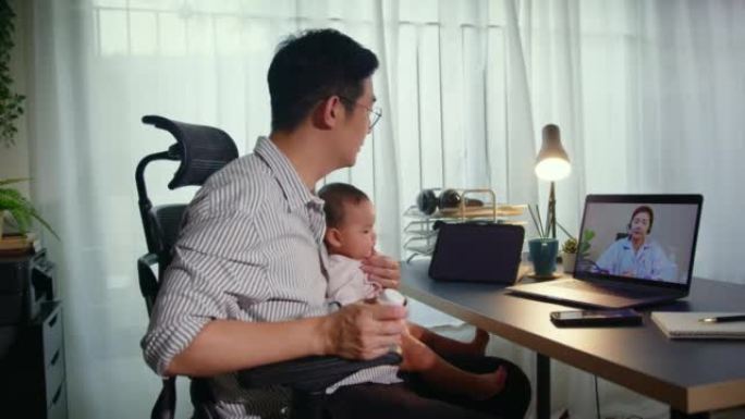 单身父亲抱着生病的男婴，通过远程医疗技术向医生询问药丸处方。虚拟护理远程医疗预约和在线咨询。