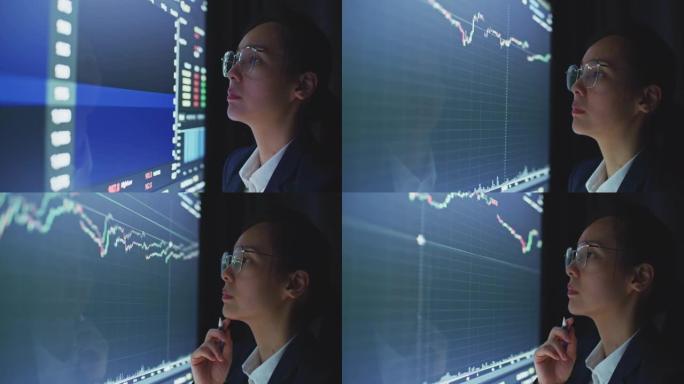 女商人在计算机监视器上查看股票数据