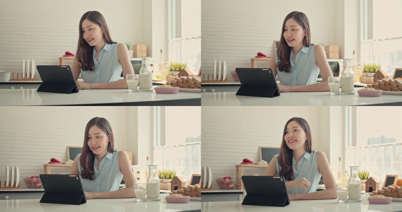 亚洲妇女在厨房中使用数字平板电脑，跟踪镜头
