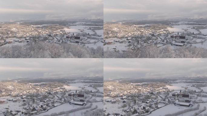 空中: 冬季早晨的阳光照亮了雪谷和郊区村庄。