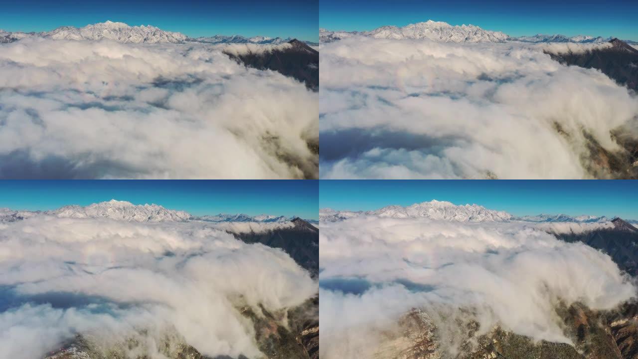 云瀑倾泻在雪山前川西雪山云海云雾俯瞰云层