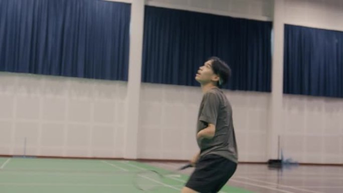 亚洲残疾人男子羽毛球运动员在羽毛球场跳跃射击。