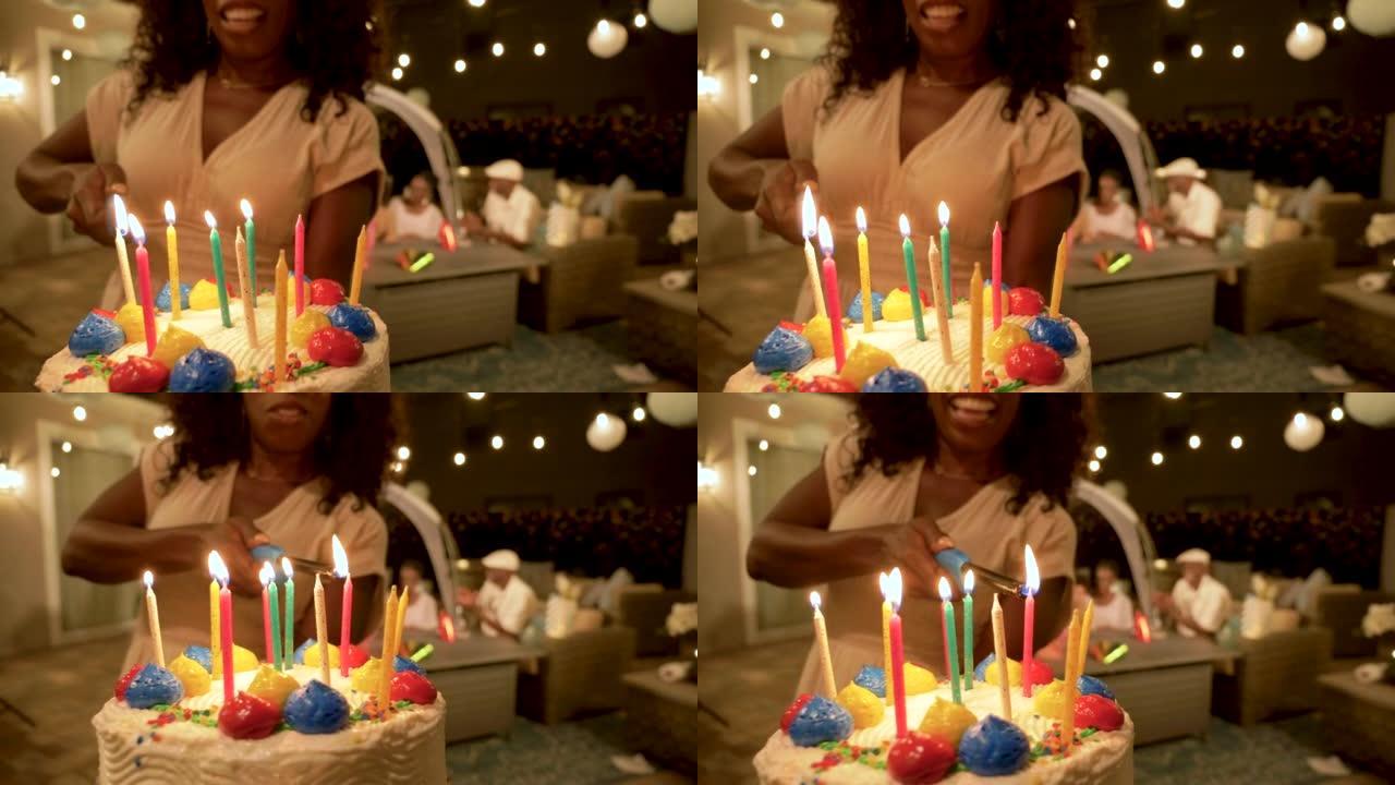女人在聚会上在生日蛋糕上点燃蜡烛