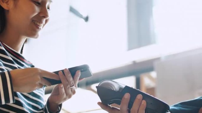 特写女性使用NFC技术通过智能手机在餐厅付款，使用智能手机进行NFC交易