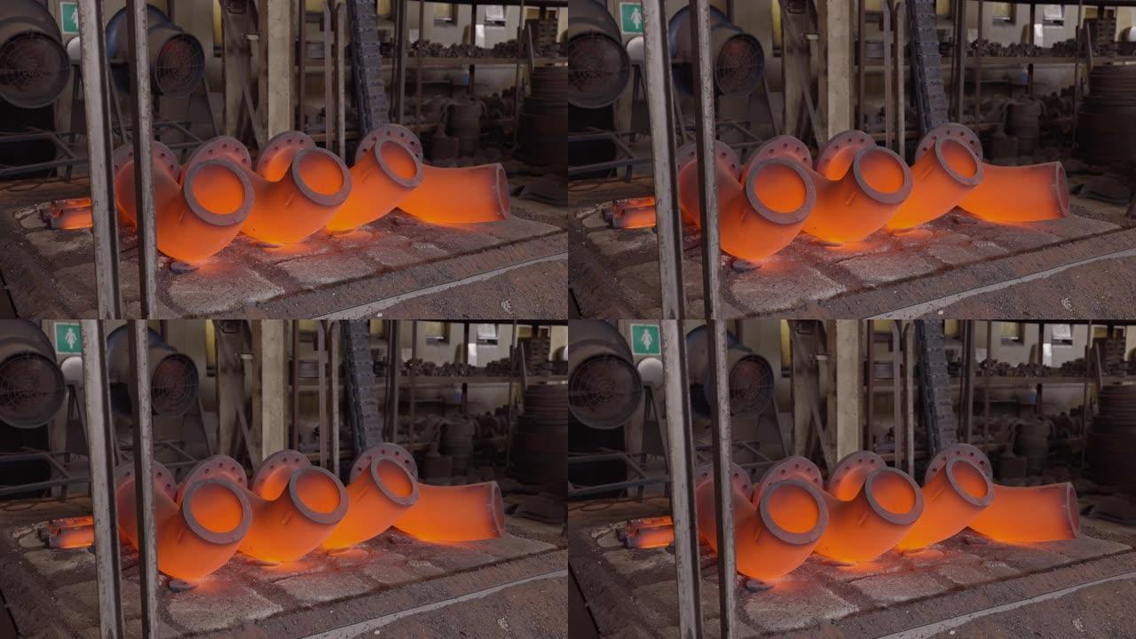 在钢铁铸造厂进行热处理的亮橙色钢管