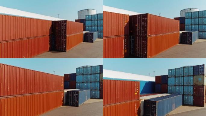 乘坐空中无人机飞行概述在造船厂物流运营中心的工业码头位置拍摄，该中心装有红色和蓝色钢制货运集装箱。日