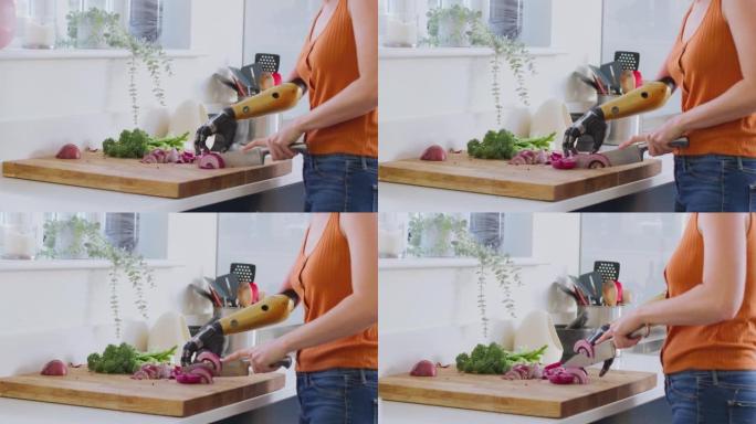 女人与女人在家里厨房里用假肢切碎洋葱并一起准备饭菜的特写镜头-慢动作拍摄