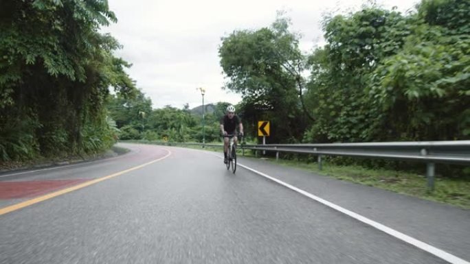 亚洲青年男子骑自行车公路旅行