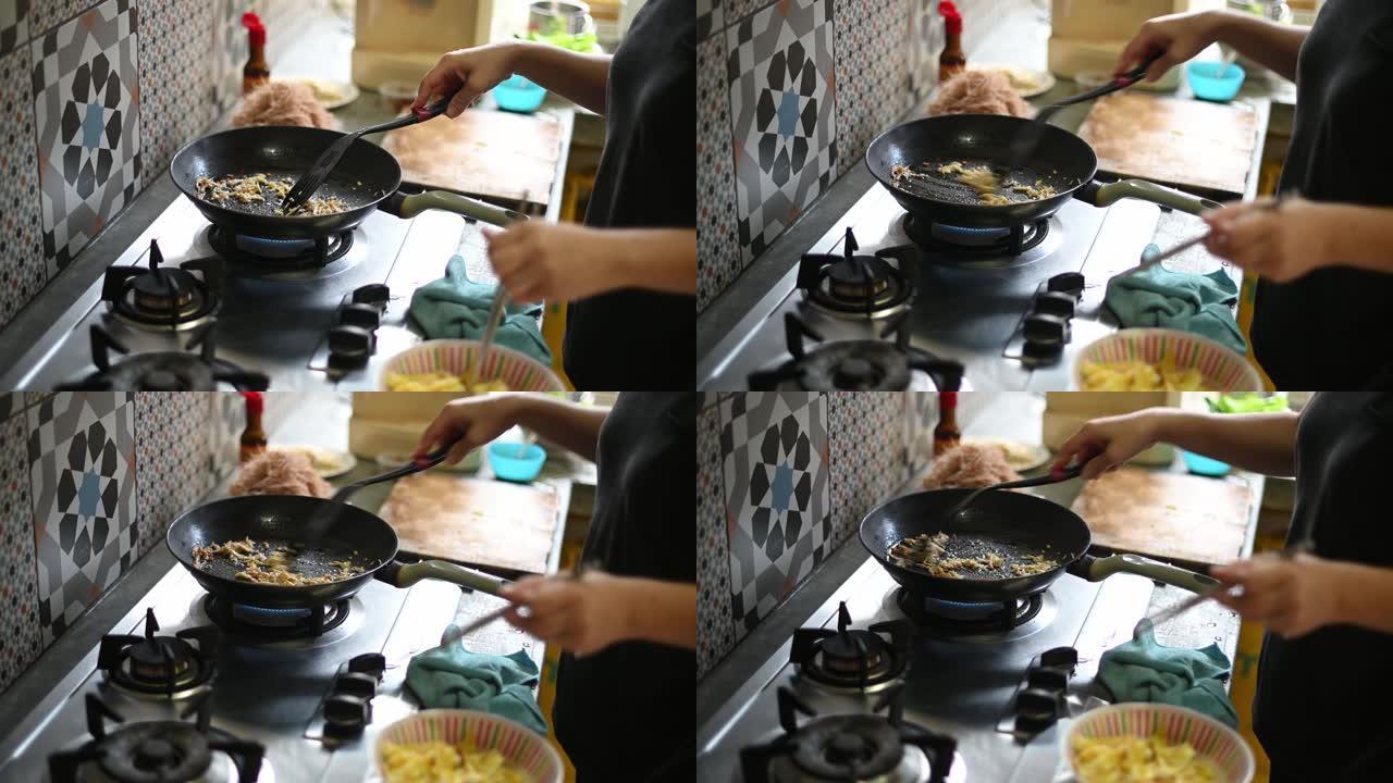 亚洲华裔妇女在厨房用炊具做饭做饭