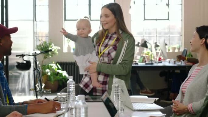 女商人，母亲和带婴儿的演讲者在办公室营销团队会议上讲话。在职妈妈经理与她的孩子和创业公司的员工进行数