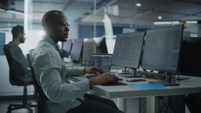 正宗办公室: 在台式电脑上工作的专业黑色IT程序员。男性网站开发人员和软件工程师开发应用程序，视频游