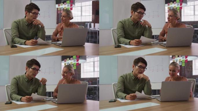 使用笔记本电脑在会议室讨论的男女商业同事