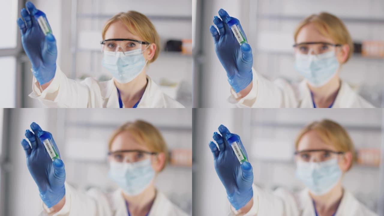 实验室研究人员戴着安全眼镜和口罩，拿着标记为Covid 19的试管