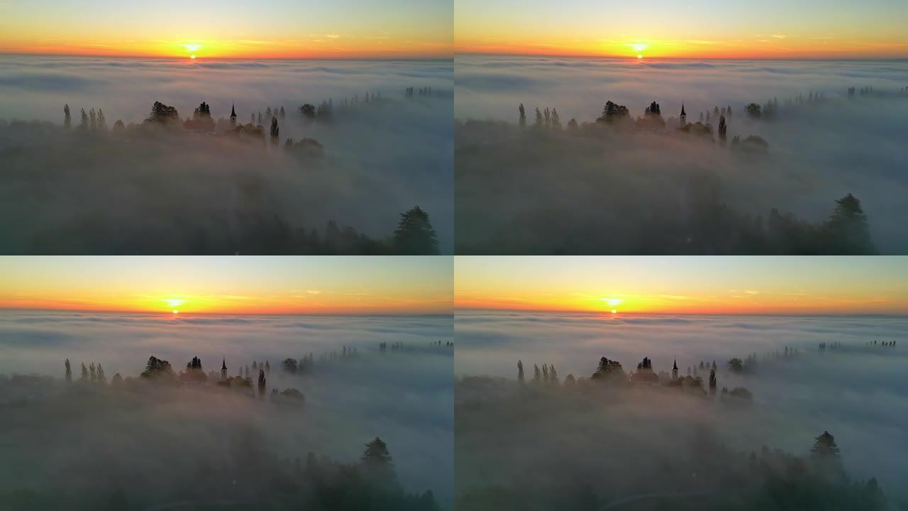 日落时分，空中雾漂浮在山顶的教堂上
