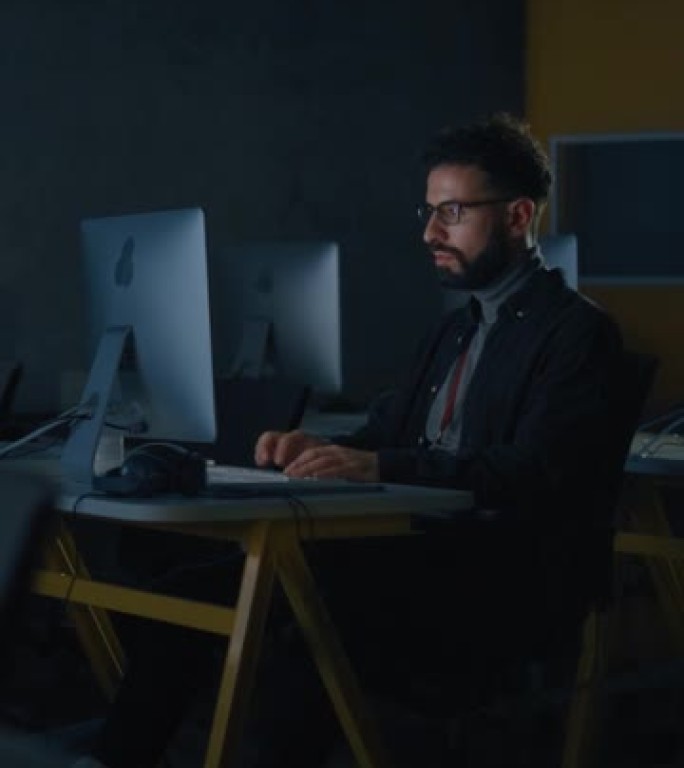 垂直屏幕: 男生独自坐在大学信息学室，晚上在计算机科学项目上工作。年轻的学者在大学学习计算机，在课堂