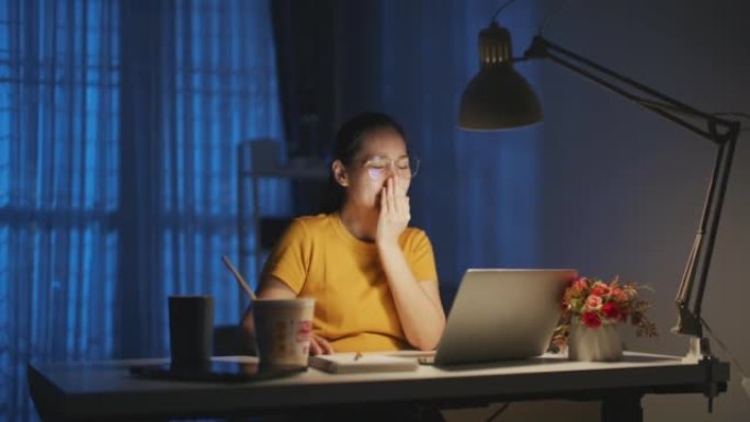 女商人在深夜工作时因笔记本电脑上的项目研究问题而感到压力