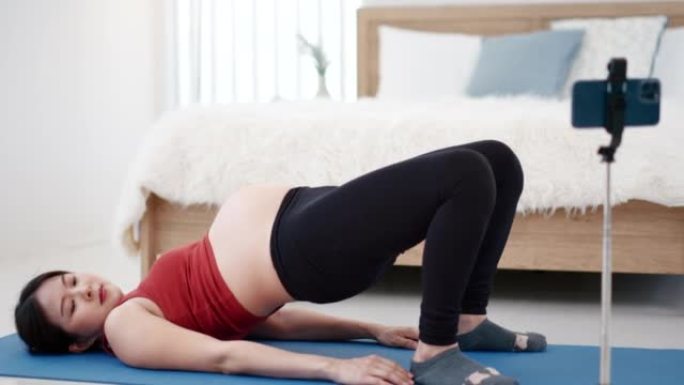 怀孕的亚洲年轻女子练习瑜伽呼吸冥想