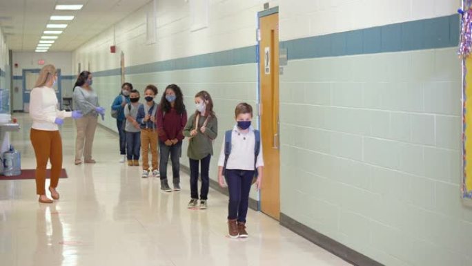 学生在新型冠状病毒肺炎期间在学校走廊戴口罩