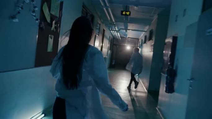 SLO MO两名身穿实验室外套的医生在医院走廊上奔跑