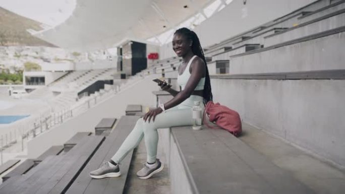 一名年轻女子在体育场使用智能手机的4k视频片段
