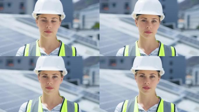 一名年轻的白人妇女在安装太阳能电池板时戴着安全帽。一位自信的女员工站在建筑工地的建筑物上的肖像