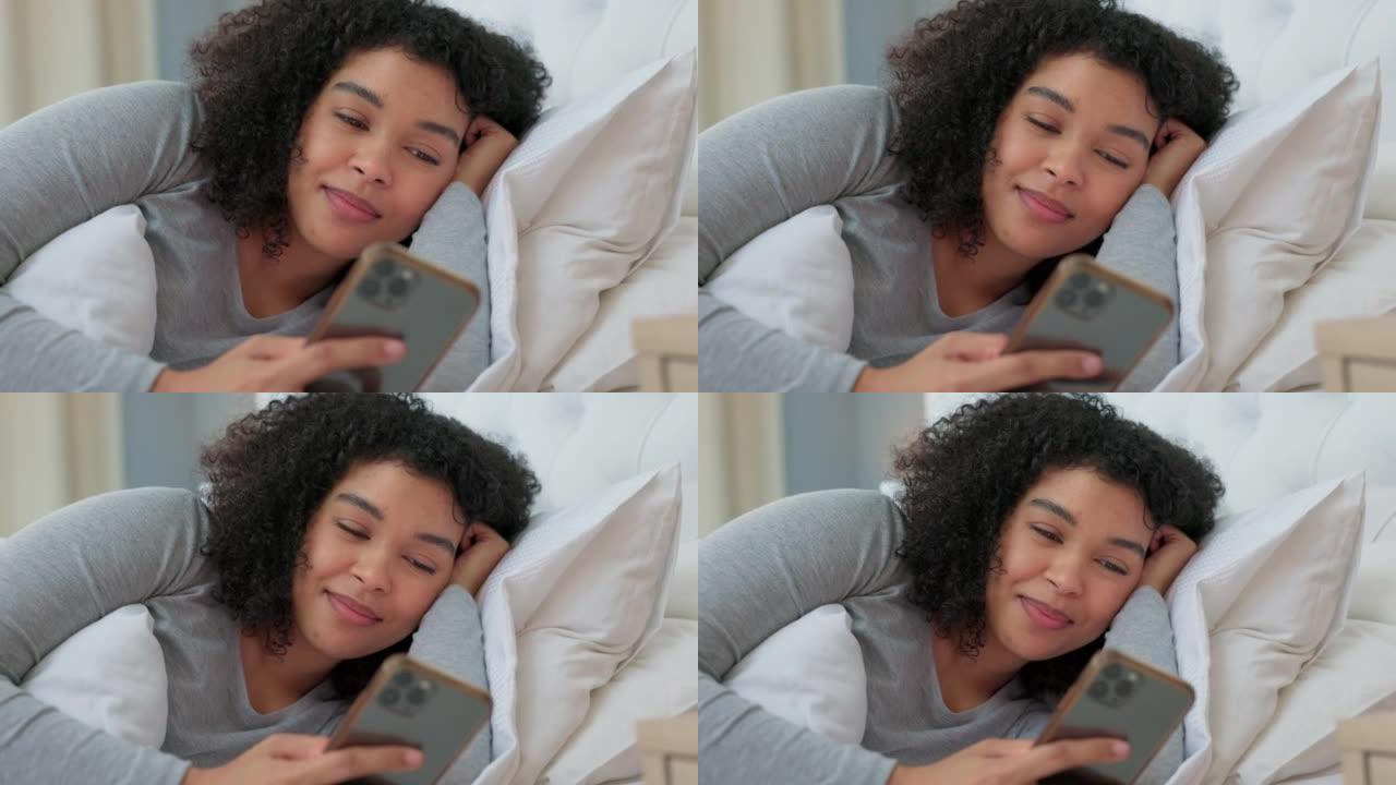 黑人妇女躺在床上，在社交媒体应用程序或互联网交流上开心的电话聊天。智能手机打字女孩，卧室微笑与网络技