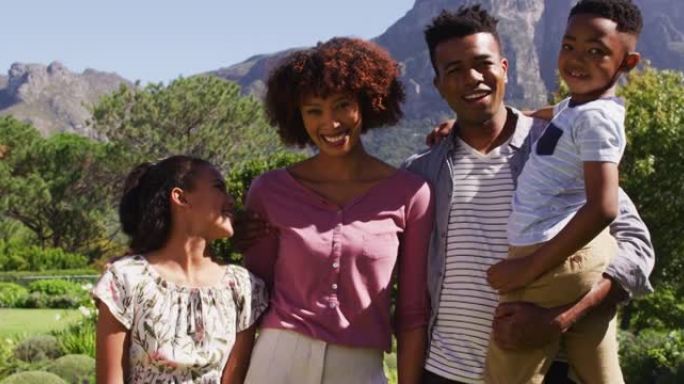 快乐的非洲裔美国父母，女儿和儿子站在户外的肖像
