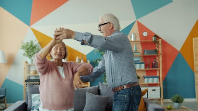 爱情夫妇的慢动作退休男女一起在家里跳舞
