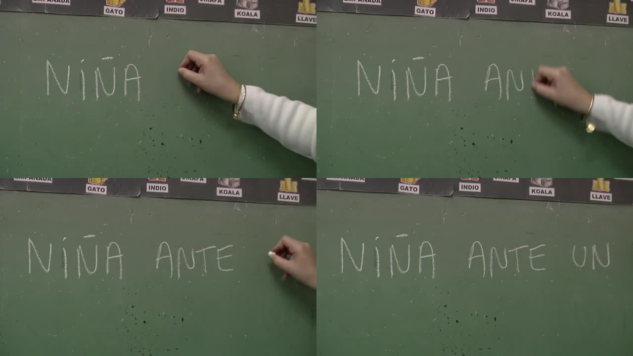 阿根廷布宜诺斯艾利斯一所公立学校内，女教师用粉笔在黑板上写字 “前面的一个女孩”。特写。