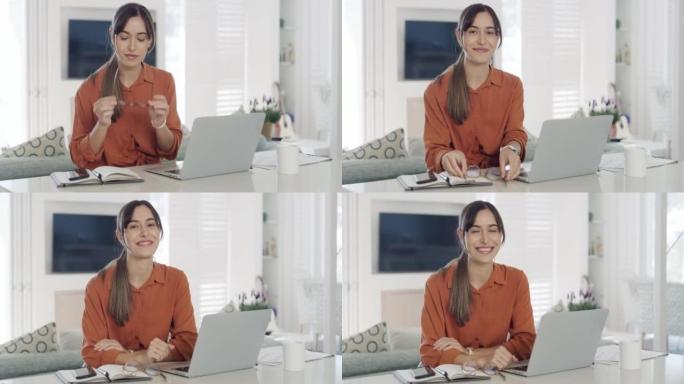 年轻女商人在家庭办公室使用笔记本电脑和阅读笔记本电脑的肖像。微笑的企业家致力于创业和计划成功。拥有家