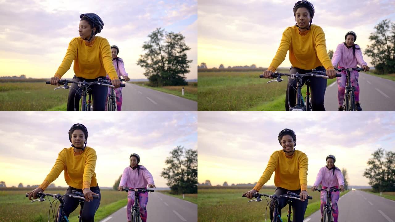 跟踪，手持拍摄两名成年女性在高速公路上快乐地骑行，慢动作