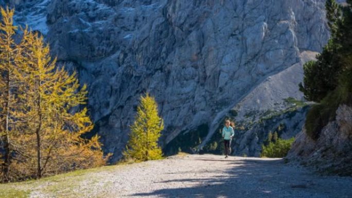 身体意识强的女人保持健康的生活方式，在山间小径上奔跑，风景令人难以置信