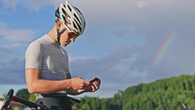 SLO MO Young骑自行车的人在乡下的某个地方使用智能手机