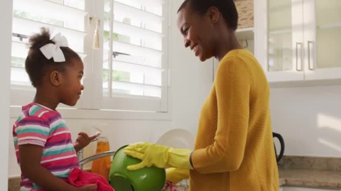 快乐的非洲裔美国母女在厨房洗碗