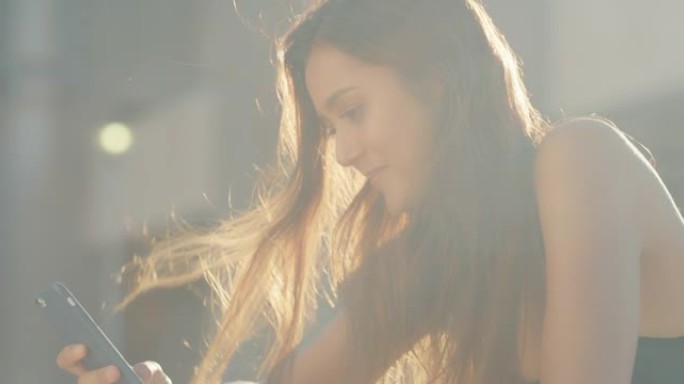 4k视频片段，一名年轻女子站在外面时使用手机