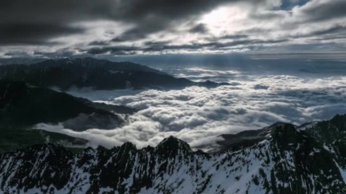 太阳刺穿云层，照亮雪山和云海