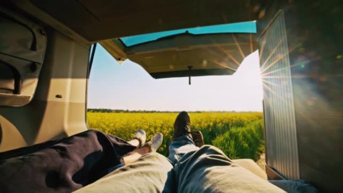 WS夫妇躺在一辆停在油菜籽田的露营车的机舱里